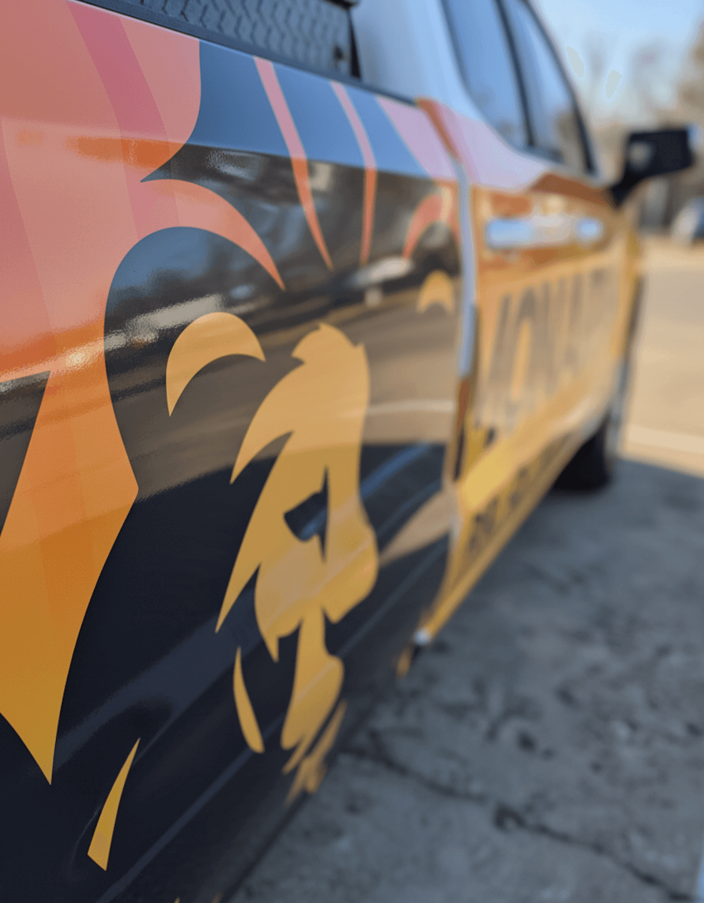 Close-up of a high-quality vinyl vehicle wrap featuring a bold lion graphic, showing the smooth finish and vibrant colors created by premium wrap materials.
